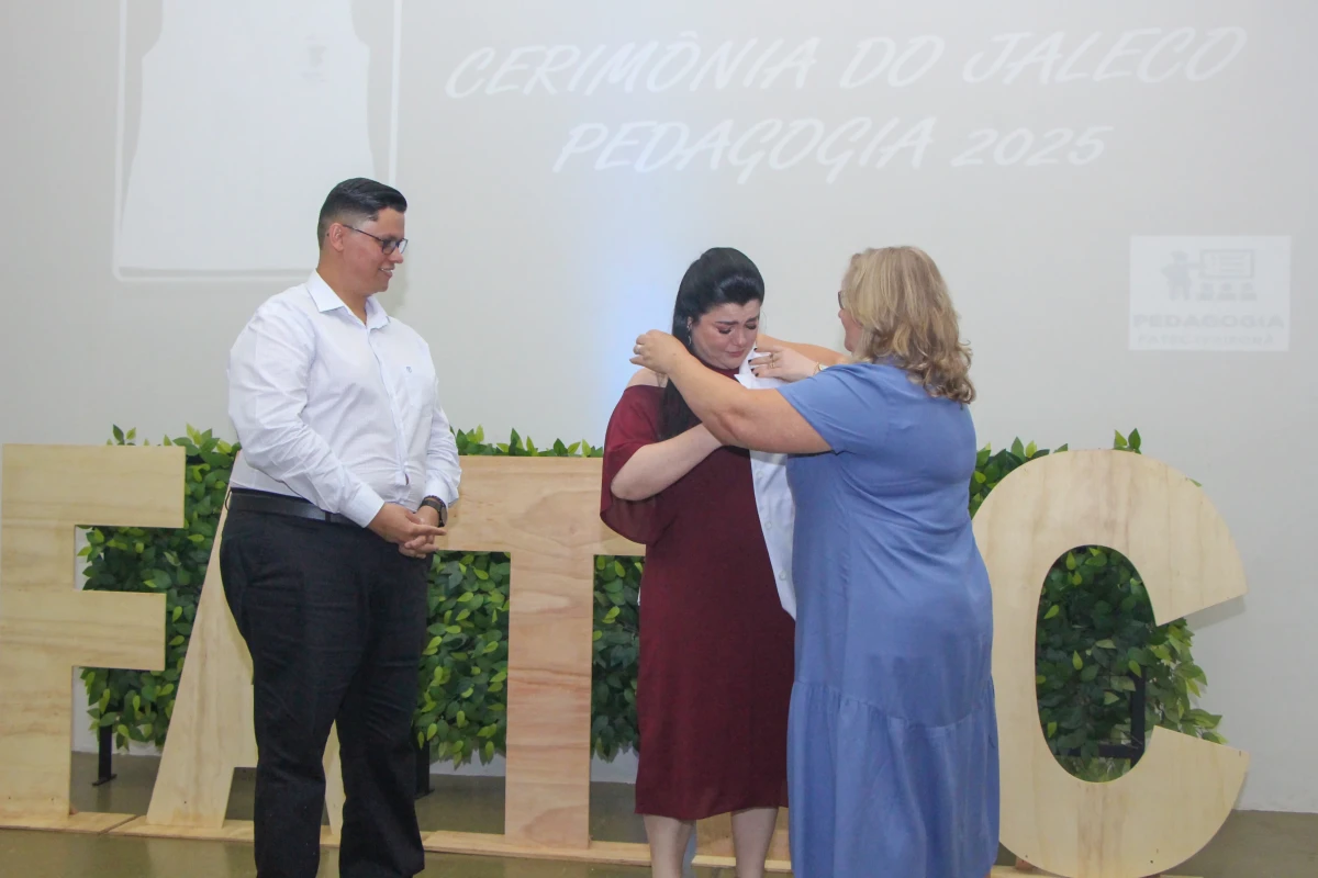 A coordenadora Fabiane Eisele Zilio, bastante emocionada, recebe o jaleco de uma de suas primeira...